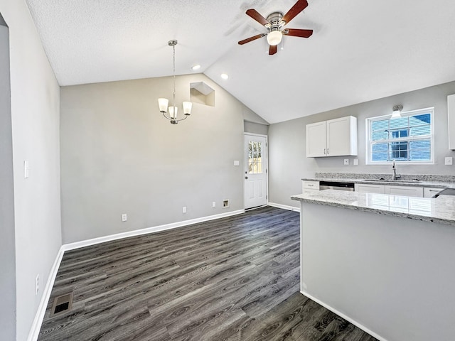 kitchen featuring light stone counters, dark wood-style flooring, a sink, visible vents, and white cabinetry