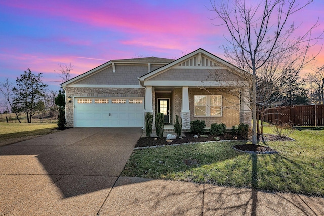 craftsman-style house featuring brick siding, a yard, fence, a garage, and driveway