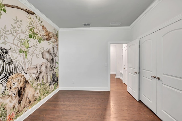 interior space featuring visible vents, crown molding, baseboards, and wood finished floors