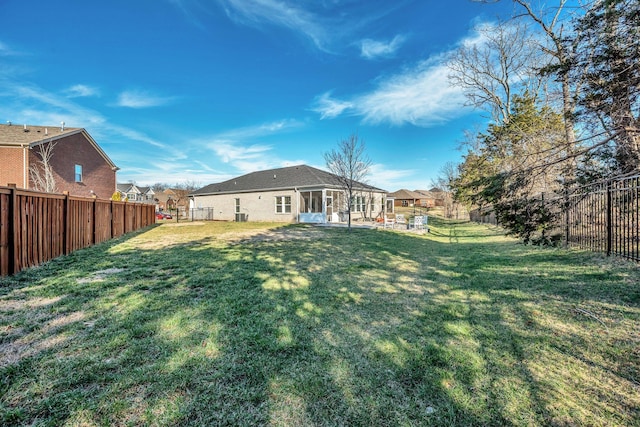 view of yard with a fenced backyard and a sunroom