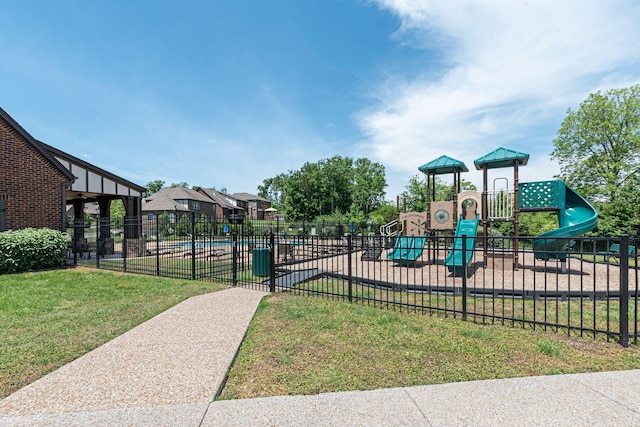 community play area featuring fence and a lawn