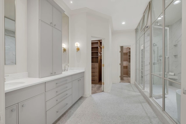 bathroom featuring double vanity, a sink, a walk in closet, and a shower stall