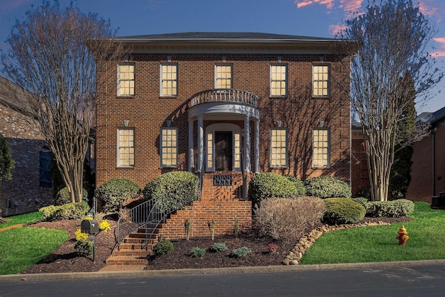 colonial home featuring brick siding and central air condition unit