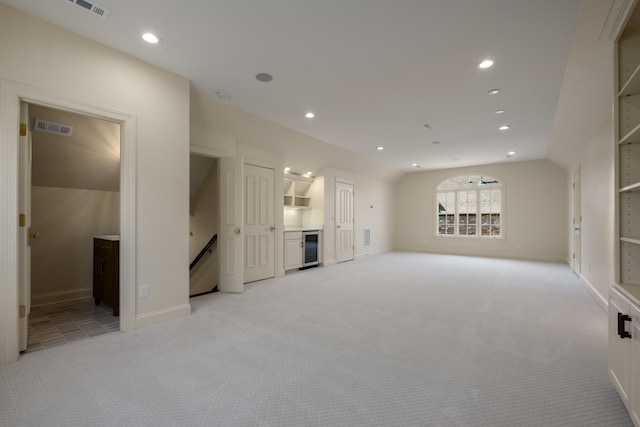 unfurnished living room featuring lofted ceiling, recessed lighting, visible vents, and light colored carpet