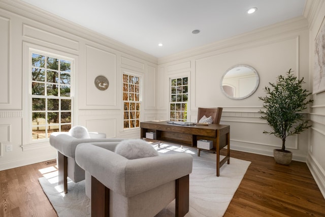 office space with ornamental molding, a healthy amount of sunlight, wood finished floors, and a decorative wall