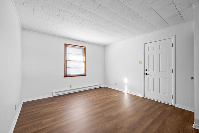 spare room with dark wood-style floors, baseboards, and baseboard heating