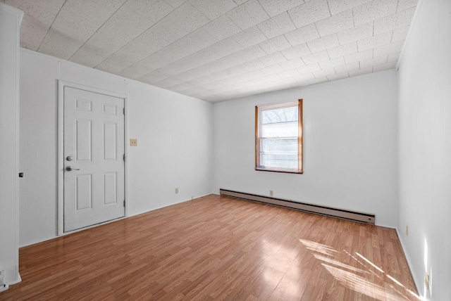 empty room with baseboard heating and wood finished floors