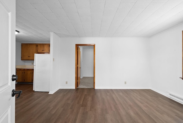 unfurnished room with baseboards, baseboard heating, and dark wood-style flooring