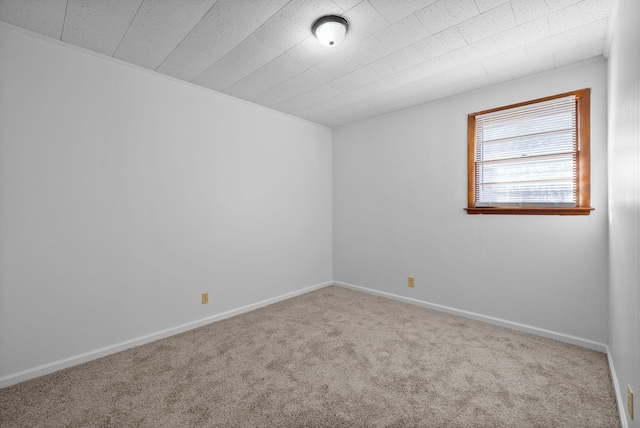 spare room featuring carpet and baseboards