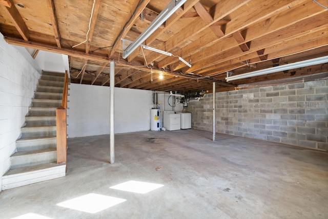 unfinished basement featuring washing machine and dryer, stairway, and electric water heater