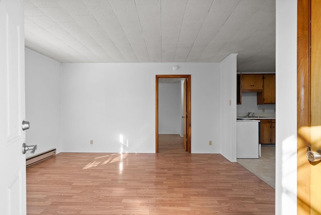 unfurnished living room with light wood-style floors and a baseboard heating unit