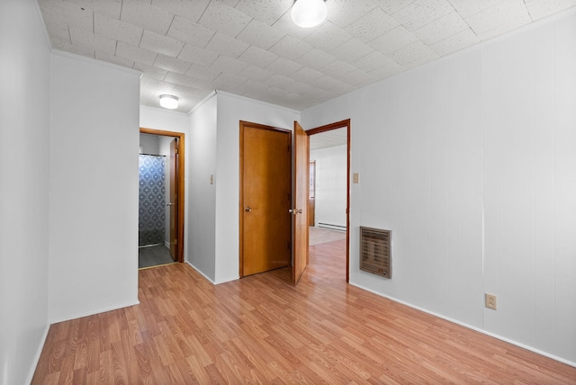 unfurnished room featuring ornamental molding, a baseboard radiator, and light wood-style flooring