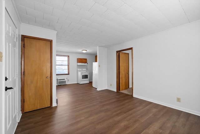 spare room with crown molding, baseboards, dark wood-type flooring, and a wall mounted AC