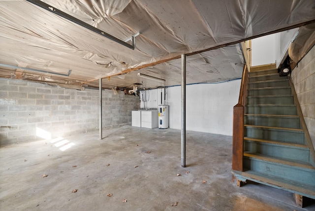 unfinished below grade area with concrete block wall, electric water heater, stairway, and separate washer and dryer