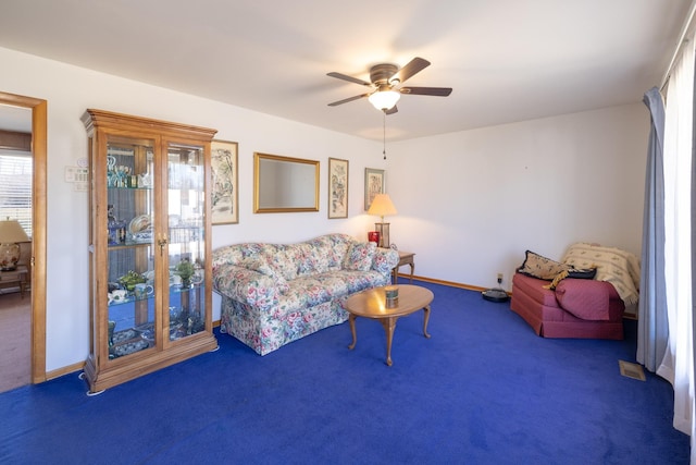 carpeted living room featuring ceiling fan and baseboards