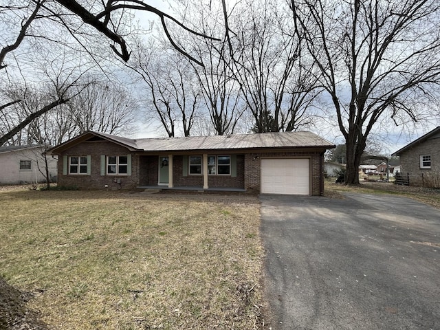 single story home featuring a garage, brick siding, driveway, and a front lawn