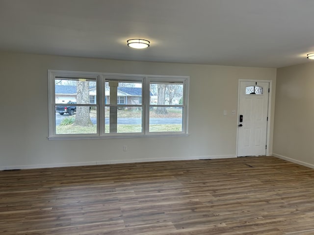 spare room with baseboards and wood finished floors