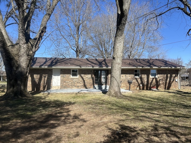 rear view of house featuring a yard and brick siding