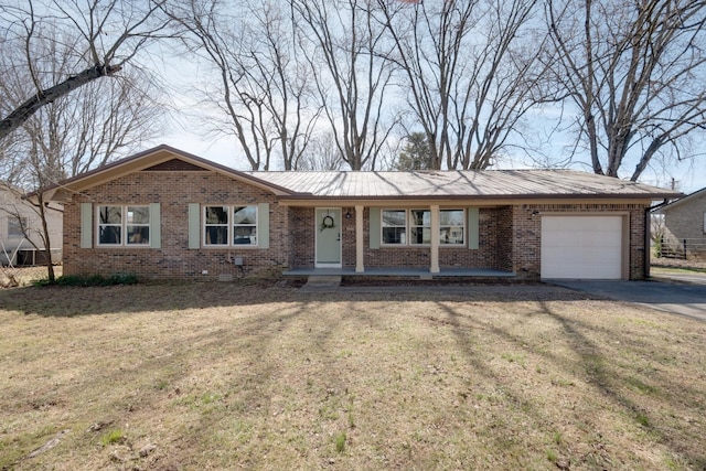 ranch-style house featuring driveway, metal roof, an attached garage, a front lawn, and brick siding