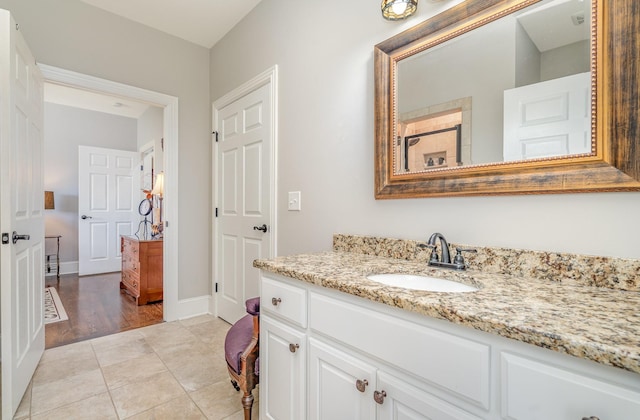 bathroom with vanity, baseboards, and tile patterned floors