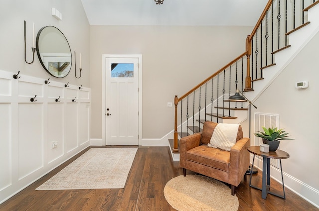 entrance foyer featuring baseboards, stairs, visible vents, and wood finished floors