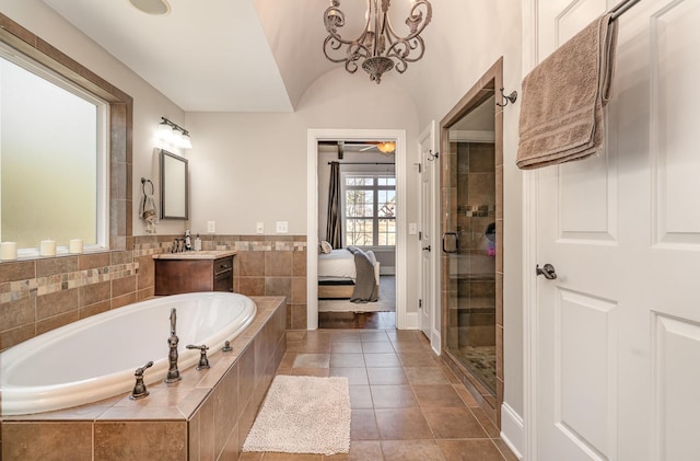 bathroom with a stall shower, ensuite bath, a bath, and vanity