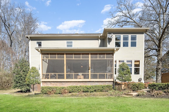 back of property featuring a sunroom and a lawn