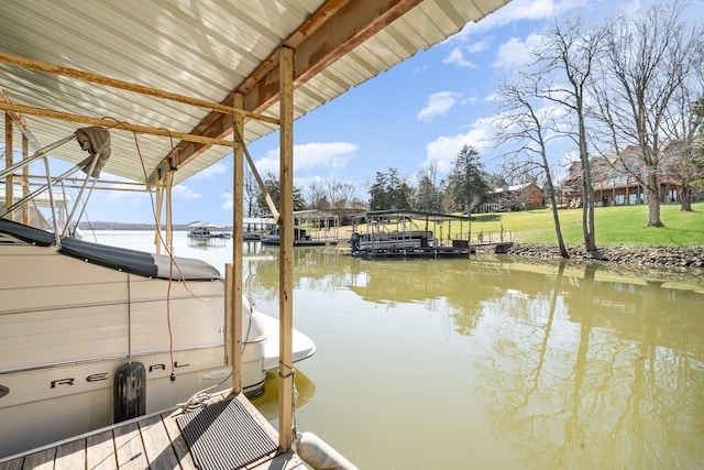 dock area with a water view and a yard