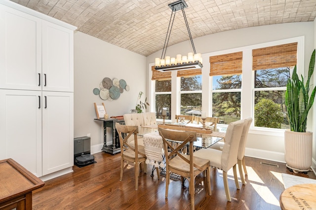 dining space with brick ceiling, baseboards, and dark wood finished floors