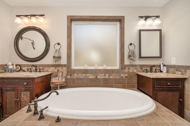 bathroom with two vanities, a sink, and a bath