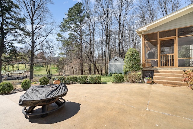 view of patio with an outbuilding, a sunroom, and a storage unit