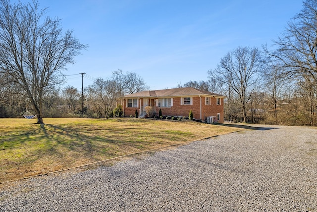 ranch-style home with driveway, a front lawn, and brick siding