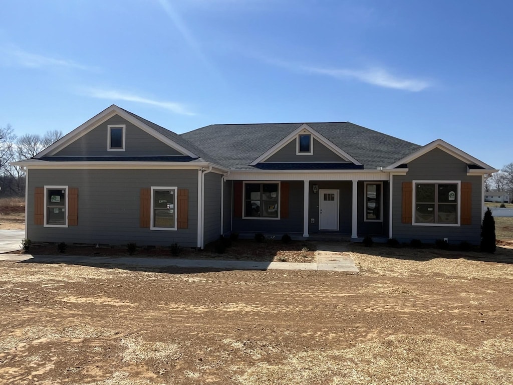 view of front of house with a porch and roof with shingles