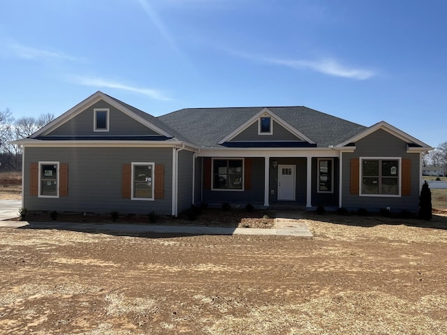 view of front of house with a porch and roof with shingles