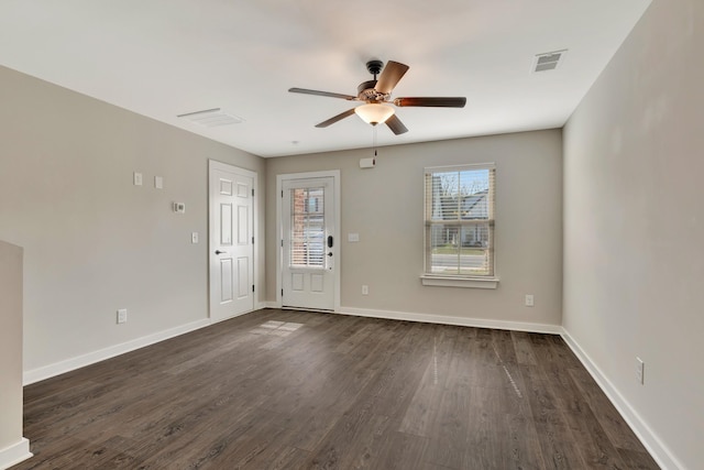 interior space featuring a ceiling fan, dark wood-style floors, baseboards, and visible vents