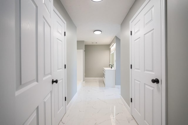 hall featuring marble finish floor and baseboards