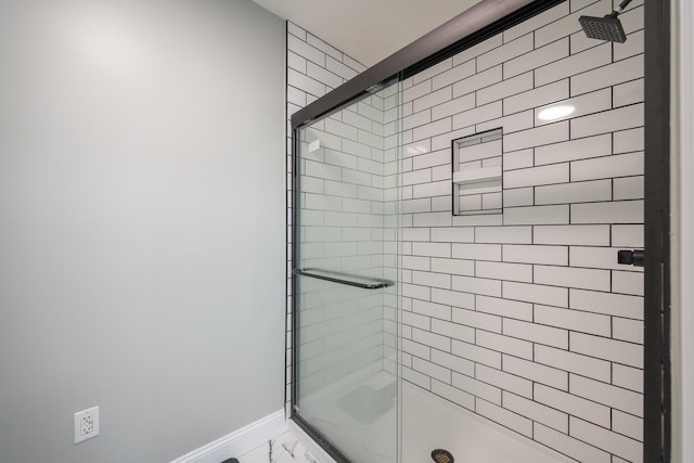 bathroom featuring a stall shower and baseboards