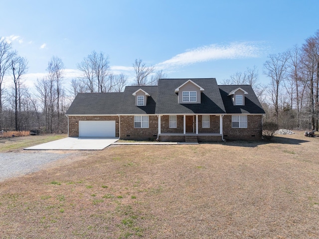 new england style home with driveway, brick siding, crawl space, an attached garage, and a front yard