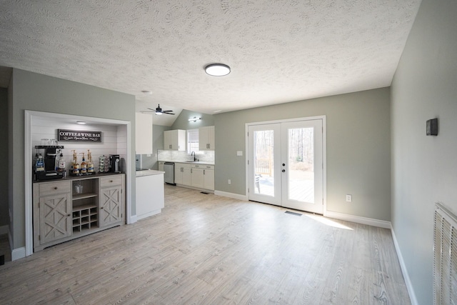 kitchen with light wood finished floors, visible vents, dishwasher, and french doors