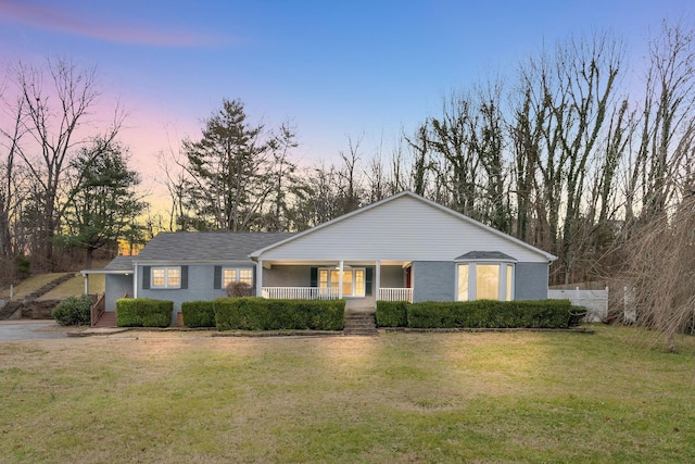 ranch-style house featuring a front yard and covered porch