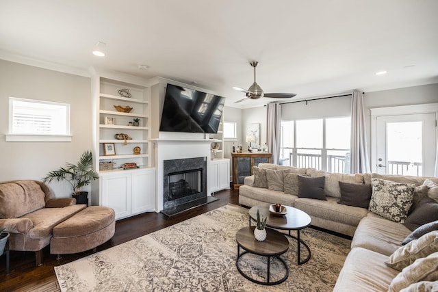 living area with built in shelves, dark wood-style flooring, a fireplace, recessed lighting, and ceiling fan