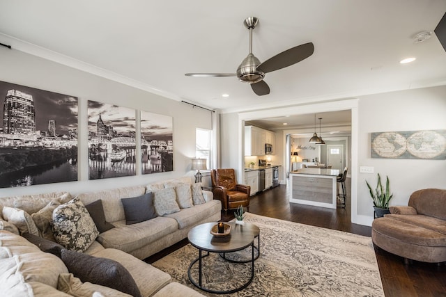 living room with a ceiling fan, dark wood finished floors, crown molding, and recessed lighting