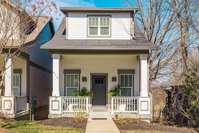 view of front facade with covered porch and a shingled roof