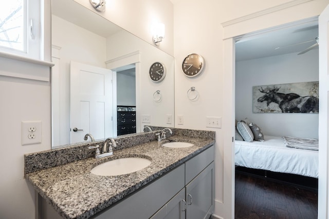 bathroom with a ceiling fan, ensuite bathroom, a sink, and wood finished floors