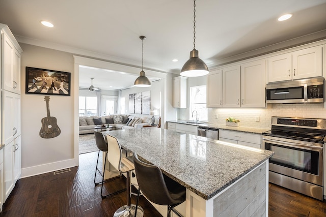 kitchen featuring appliances with stainless steel finishes, dark wood finished floors, a sink, and backsplash