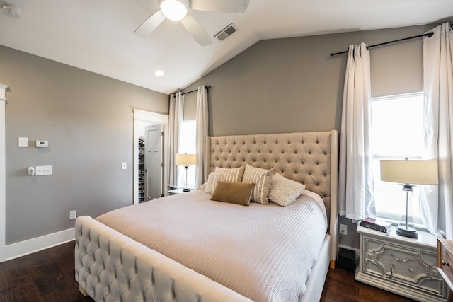 bedroom with ceiling fan, dark wood-style flooring, visible vents, baseboards, and vaulted ceiling