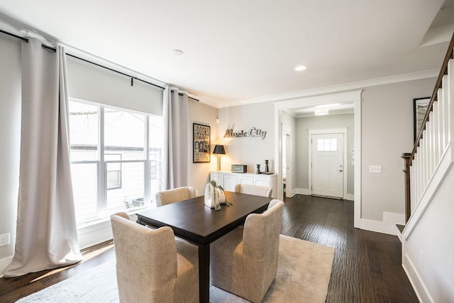 dining area with crown molding, plenty of natural light, dark wood-style floors, and stairs