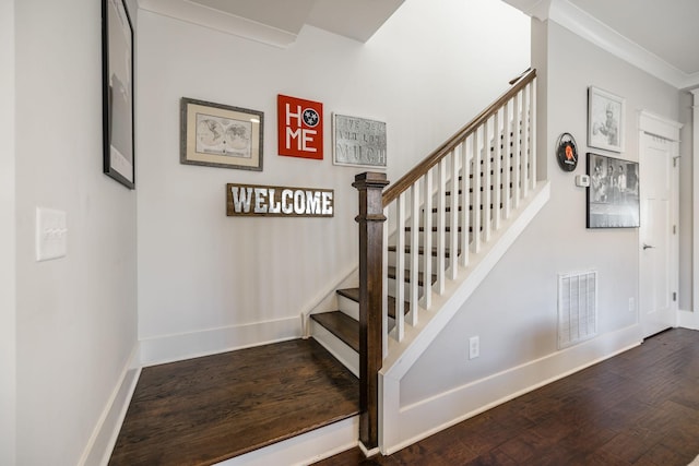 stairs with wood-type flooring, visible vents, and baseboards