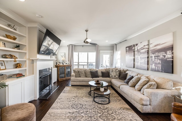 living area featuring dark wood-style floors, recessed lighting, a fireplace, and built in shelves