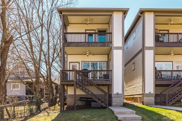 back of house with ceiling fan, stairs, a balcony, and fence